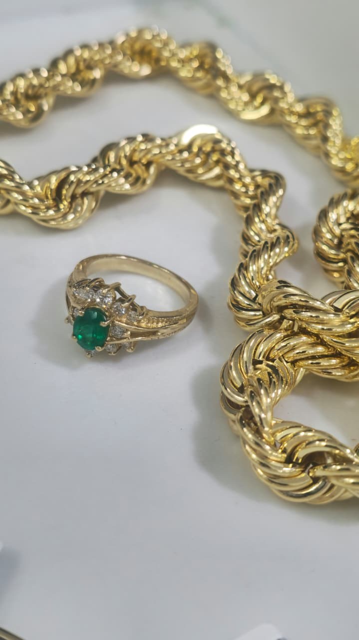 Anillo con piedra verde y joyería VGOLD en composición fotográfica de catálogo